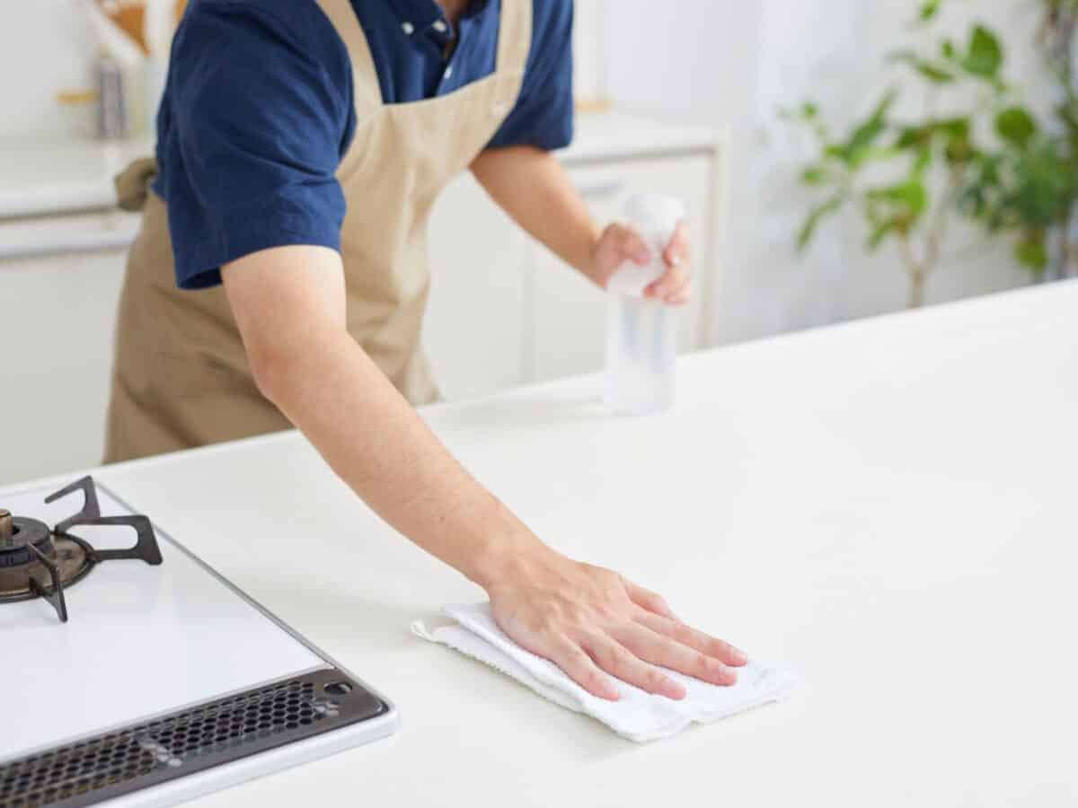 Een medewerker poetst het keukenaanrecht.